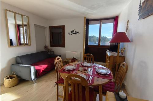 una sala de estar con una mesa y un sofá en T2 cosy à Puyvalador - Ski & lac, en Puyvalador