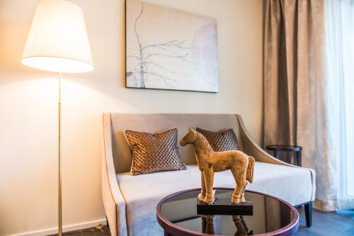 a living room with a couch and a table with a horse statue at Hotel My Way Zürich Wallisellen in Wallisellen