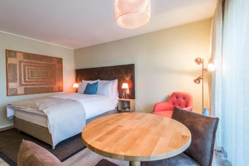 a hotel room with a bed and a table and chairs at Hotel My Way Zürich Wallisellen in Wallisellen