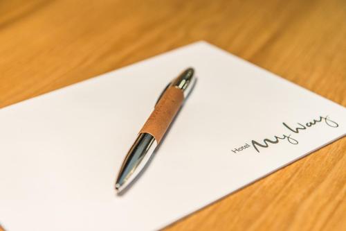 a pen sitting on top of a piece of paper at Hotel My Way Zürich Wallisellen in Wallisellen