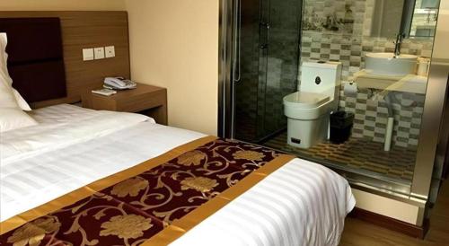 a bedroom with a bed and a shower and a toilet at City 118 Hotel Aodele in Songguantun