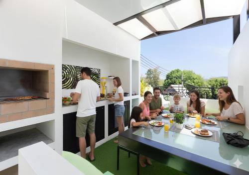 拉威海滩Modern Zen Oasis Villa Style - Pool, Rooftop Views & Playground - All-Inclusive - 4BR-3BA的一群人坐在厨房的桌子旁