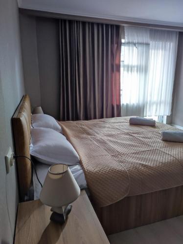 a bedroom with a bed with a lamp and a window at White Peaks in Mestia
