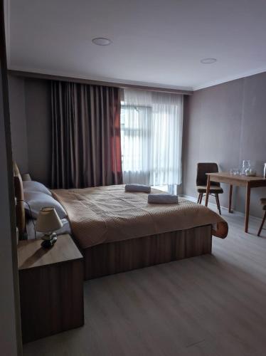 a hotel room with a bed and a table and a window at White Peaks in Mestia