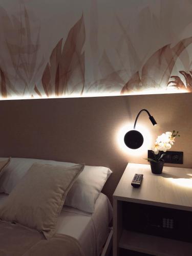 a bedroom with a bed and a desk with a lamp at Pension Oasis Alicante in Alicante