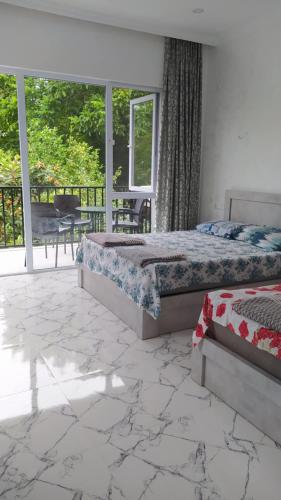 a bedroom with two beds and a balcony at Emzari's Apartment in Kobuleti