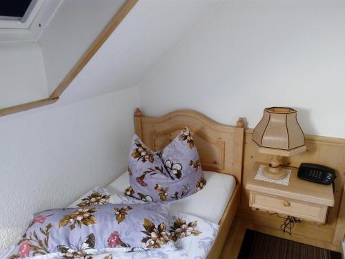 ein Schlafzimmer mit einem Bett mit einer Lampe und einem Telefon in der Unterkunft Landhotel Eichenkrug in Groß Breese