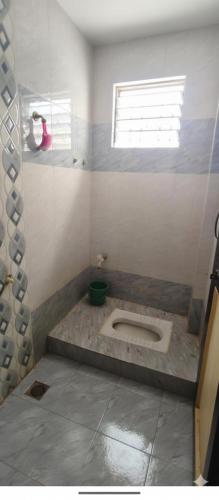 a bathroom with a toilet in the middle of the room at Atithi Niwas, Best hotel near khandoba temple Jejuri in Jejūri