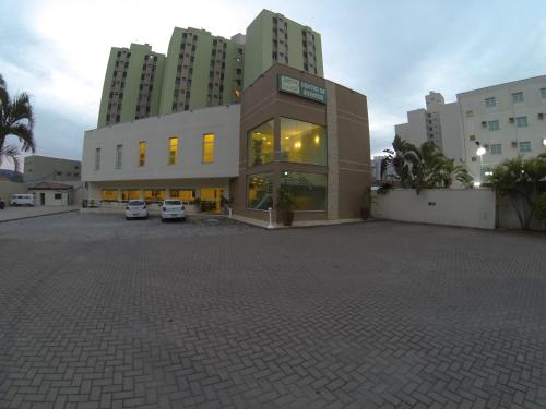 a large building with cars parked in a parking lot at Hotel Serra de Jundiaí in Jundiaí