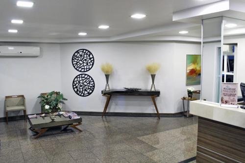 a lobby with a table and some vases on the wall at Hotel Serra de Jundiaí in Jundiaí