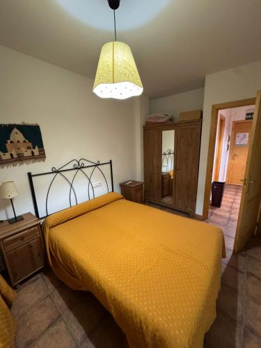 a bedroom with a yellow bed and a lamp at Vivienda Chorrillos del Lavadero in La Iruela