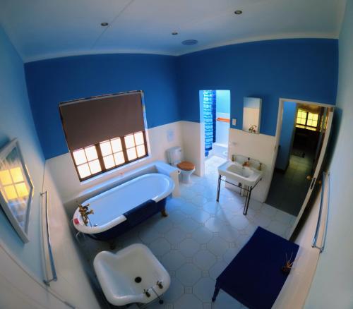 een blauwe badkamer met een bad en een wastafel bij Irish Hills - two bedroom apartment in Hilton