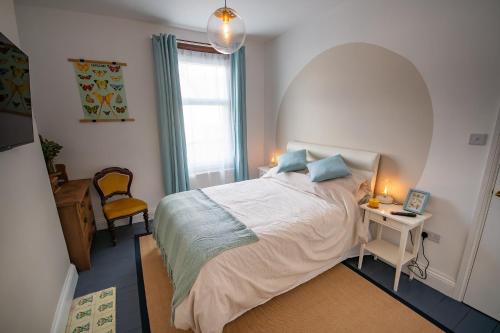 a bedroom with a bed and a table and a window at Spacious Victorian 4 Bed l Cocktail Bar Spa Bath Workspaces in Plymouth