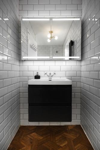 a bathroom with a sink and a mirror at Spacious Victorian 4 Bed l Cocktail Bar Spa Bath Workspaces in Plymouth