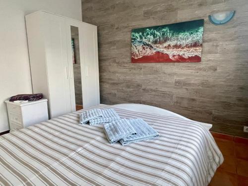 a bedroom with a bed with two towels on it at Villa Cristipaulo in Praia de Faro