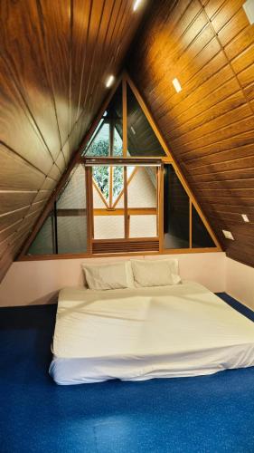 a white bed in a room with a window at Cloud Peak in Vagamon