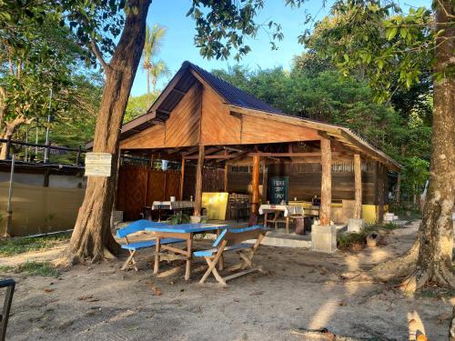 a building with a table and chairs in front of it at Moonshine Phayam beach resort & restaurant in Ranong