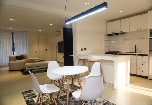 Una cocina y una sala de estar con mesa y sillas. en The Estoria Lagos, en Ikeja