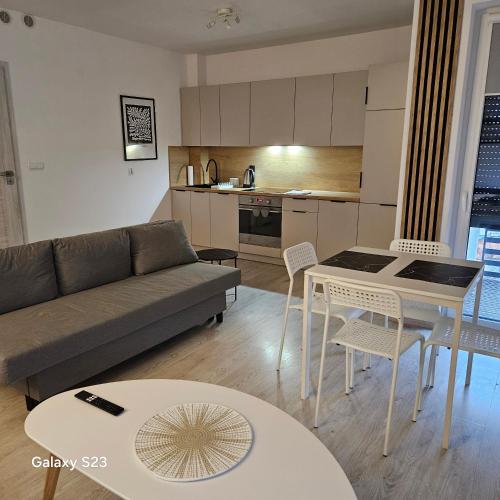 een woonkamer met een bank, een tafel en stoelen bij Studio Człuchów Centrum in Człuchów