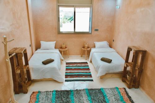a room with two beds and a rug at Cool Surfers Morocco in Agadir