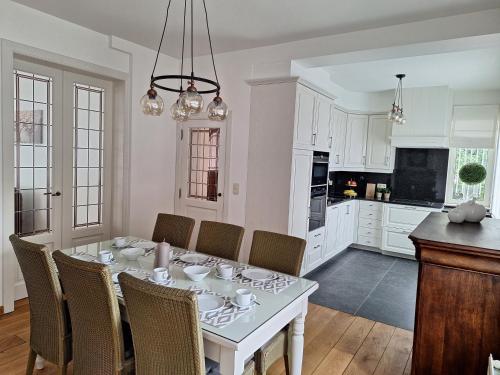 a kitchen and dining room with a white table and chairs at Villa Bonifica in Riemst