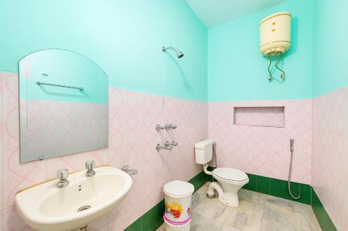 een roze badkamer met een wastafel en een toilet bij Hotel Dreamline Teerth GH Near Temple # Kashi Temple - Restaurant # Free WIfi Service - Fully Air Conditioning Rooms# Best Premium Hotel In Varanasi in Varanasi