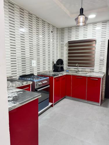 a kitchen with red cabinets and a stove at Amik Homes in Aso