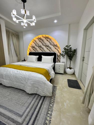 a bedroom with a large bed and a chandelier at Amik Homes in Aso