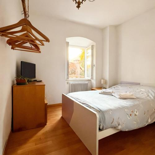 a white bedroom with a bed and a window at El Me Popo in Segonzano