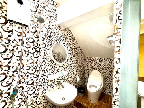 a bathroom with a toilet and a sink and a mirror at Vista Inn Patong in Patong Beach