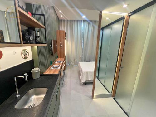 uma casa de banho com um lavatório e um chuveiro com uma cama em Lm Get Sense em João Pessoa