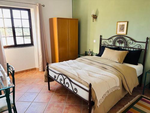 een slaapkamer met een groot bed in een kamer bij Quinta Monte da Azinheira in Amareleja