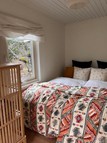 a bedroom with a bed with a quilt and a window at Sofias Lovely Little House in Stockholm