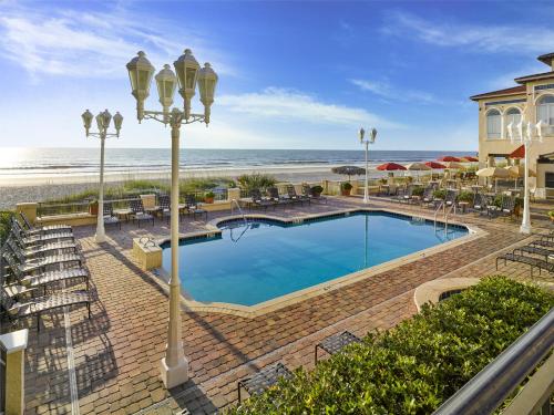 a swimming pool next to a beach and the ocean at The Lodge & Club at Ponte Vedra Beach in Ponte Vedra Beach
