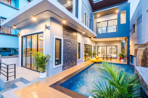 a house with a swimming pool in the middle of it at Lom-Talay poolvilla huahin in Hua Hin