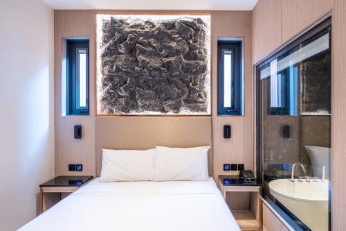 a bedroom with a bed and a sink and a mirror at Tonnam pool villa in Nong Prue