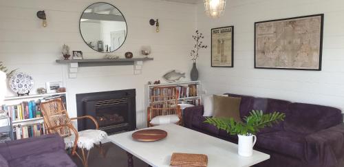 a living room with a couch and a table and a mirror at Kipsie Cottage - Point Lonsdale in Point Lonsdale