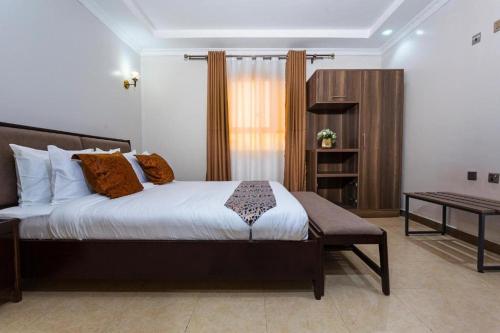 Un dormitorio con una cama grande y un escritorio. en Nokras SilverOak Hotel, Embu, en Embu