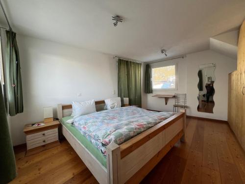a bedroom with a large bed and a window at Chesa Tre Piz in Maloja