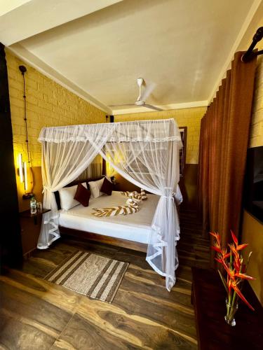 a bedroom with a white bed with a canopy at WILD PARADISE Apt in Unawatuna
