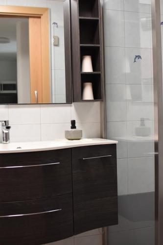 a bathroom with a sink and a mirror and a shower at Ferienwohnungen Pircher in Rablà