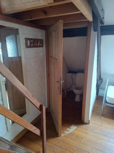 an attic room with a staircase and a toilet at Cheap hotel near Brussels airport in Kortenberg
