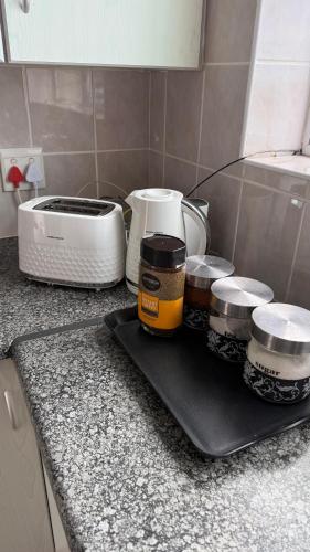 a kitchen counter with a counter top with jars and a toaster at Lilies and Leopards Holiday Home B & B in Mossel Bay