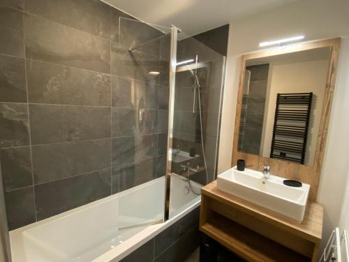 ein Badezimmer mit Waschbecken, Dusche und Badewanne in der Unterkunft Appart Neuf Saint Gervais 4 personnes in La Celle-sous-Gouzon