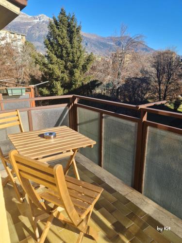 Pan Kit RoomS في أَويستا: طاولة وكراسي خشبية على شرفة مع جبال