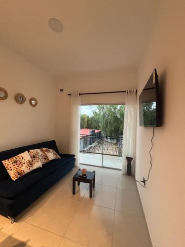 a living room with a black couch and a window at Edificio Anuar Auad in Tarija
