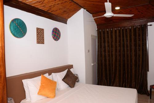 Un dormitorio con una cama y un ventilador de techo. en Mbilimbi Malazi, en Zanzíbar