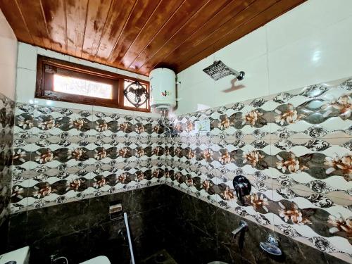 a bathroom with a bunch of monkey tiles on the wall at Narkanda Heights Rooms in Nārkanda
