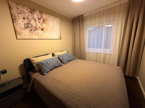 a small bedroom with a bed and a window at Telšiai Modern Central Apartments in Telšiai