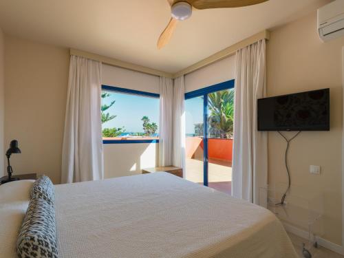 een slaapkamer met een bed en uitzicht op de oceaan bij Long Beach By CanariasGetaway in Corralejo